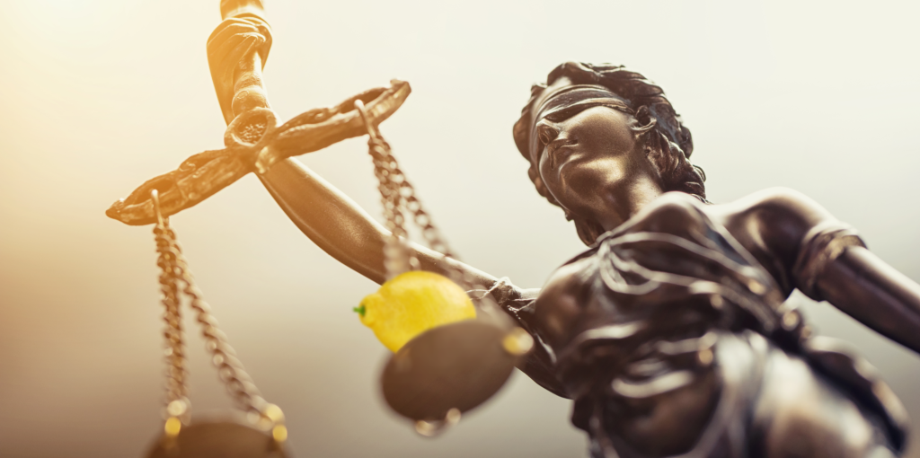 Lady justice holding scales with a lemon on one side.