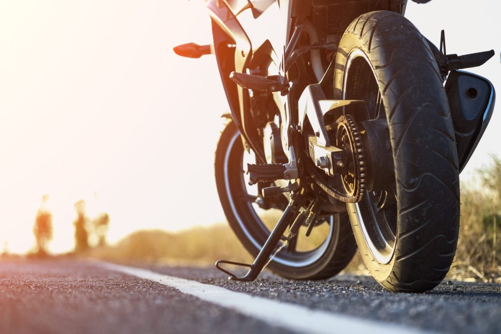 A Motorcycle Parked On The Road Right Side And Sunset